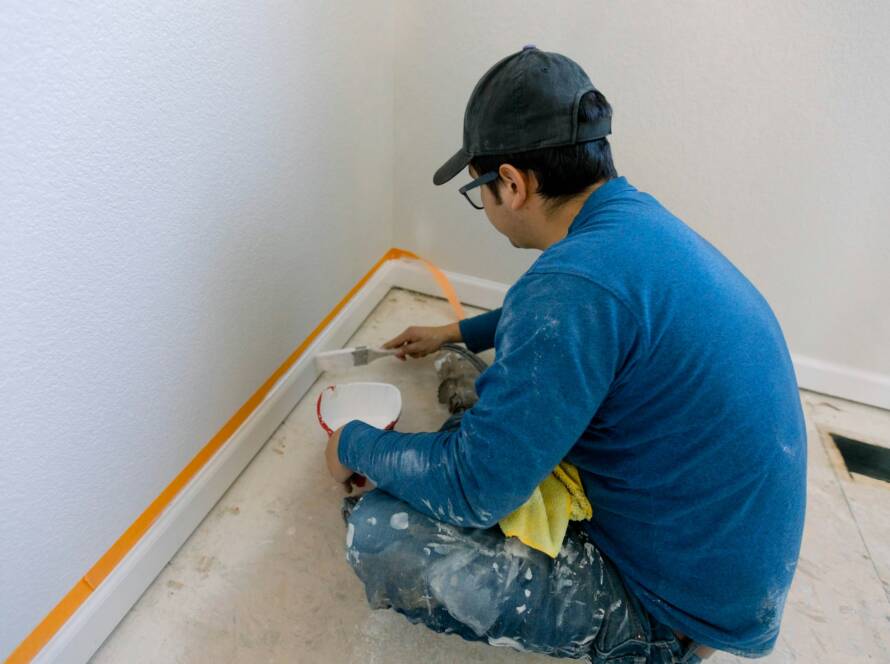 Construction worker painting the trim on a home remodel
