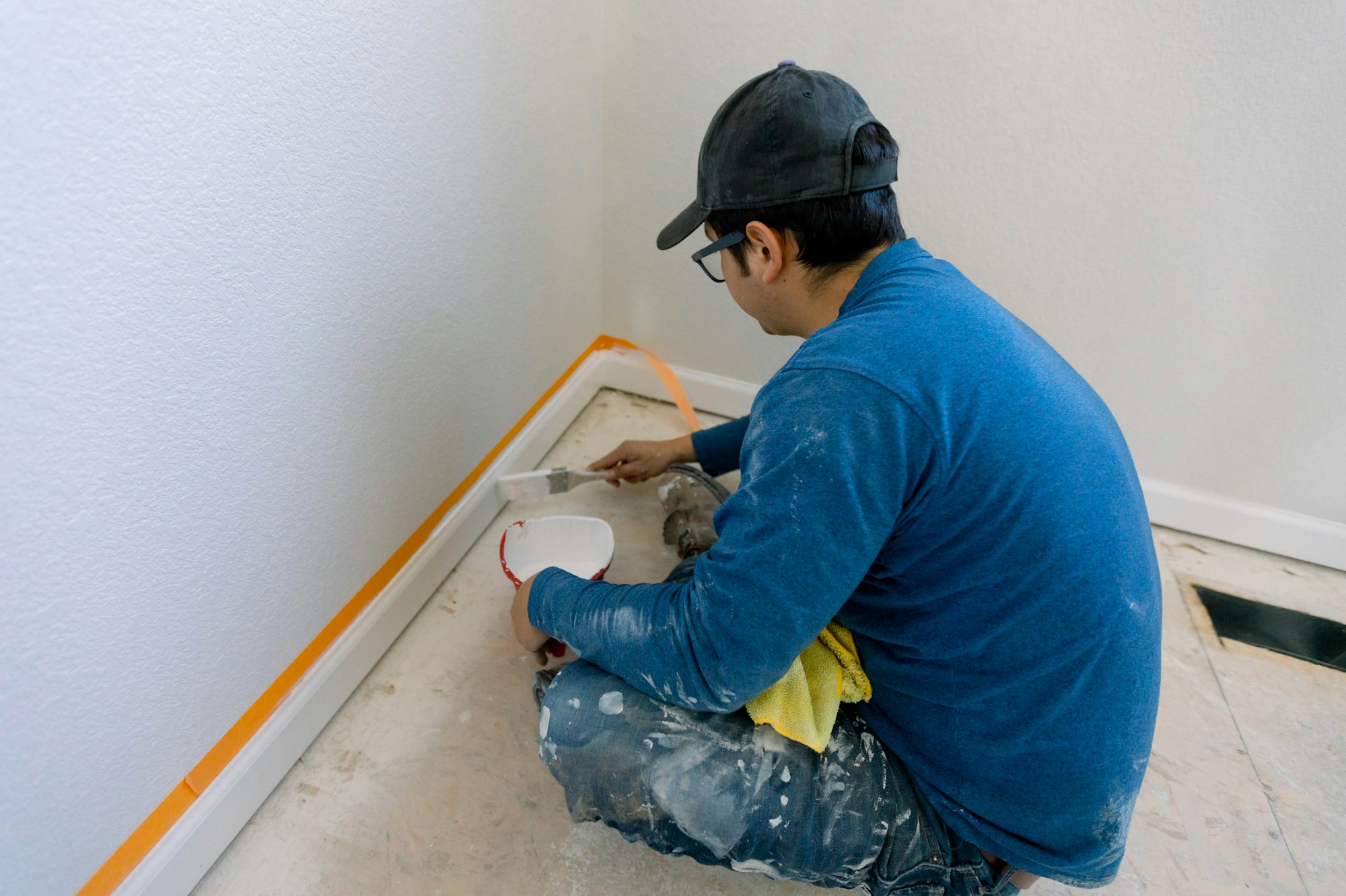 Construction worker painting the trim on a home remodel