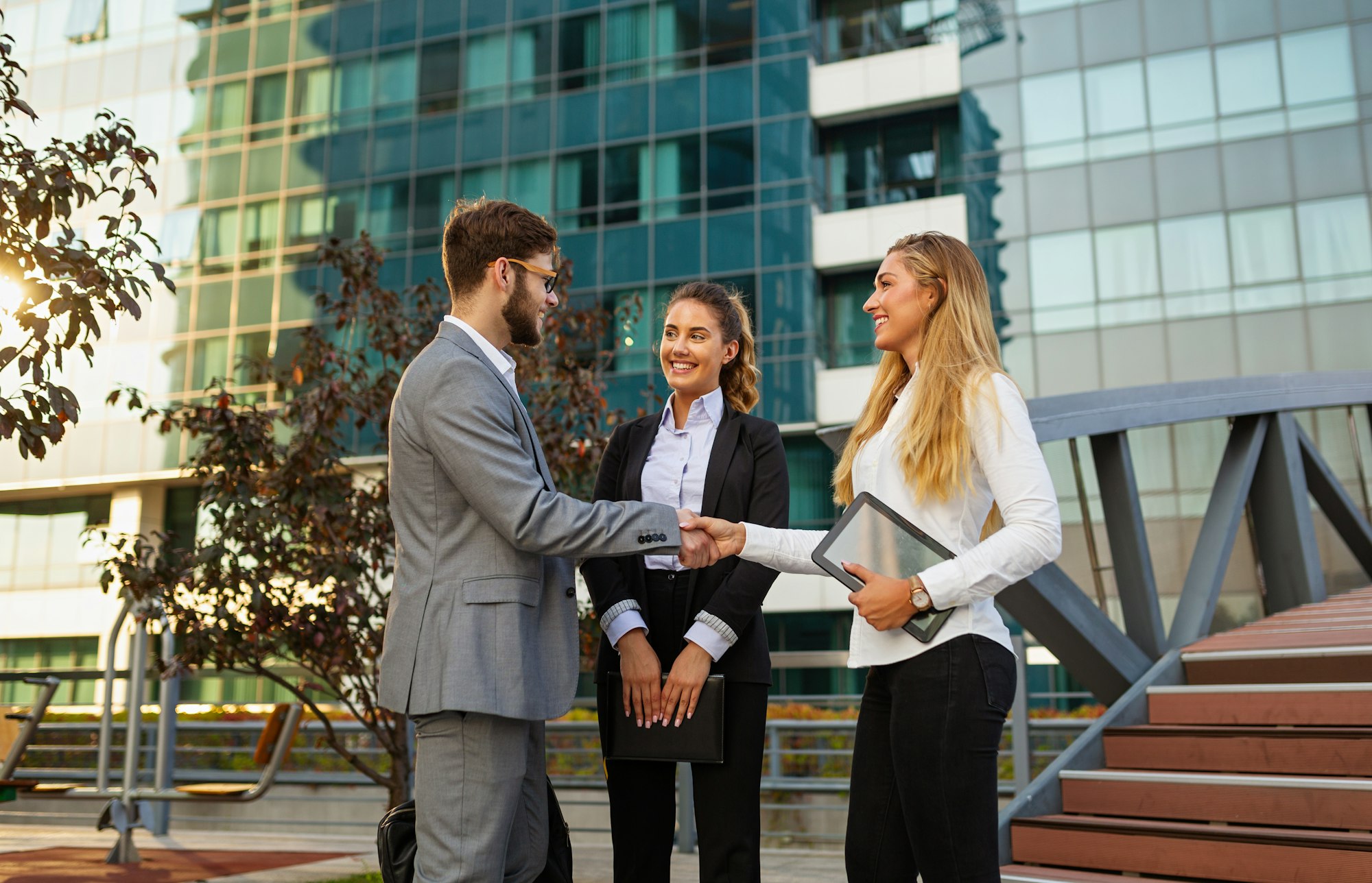 Group of business man and woman team at office shaking hands outdoors