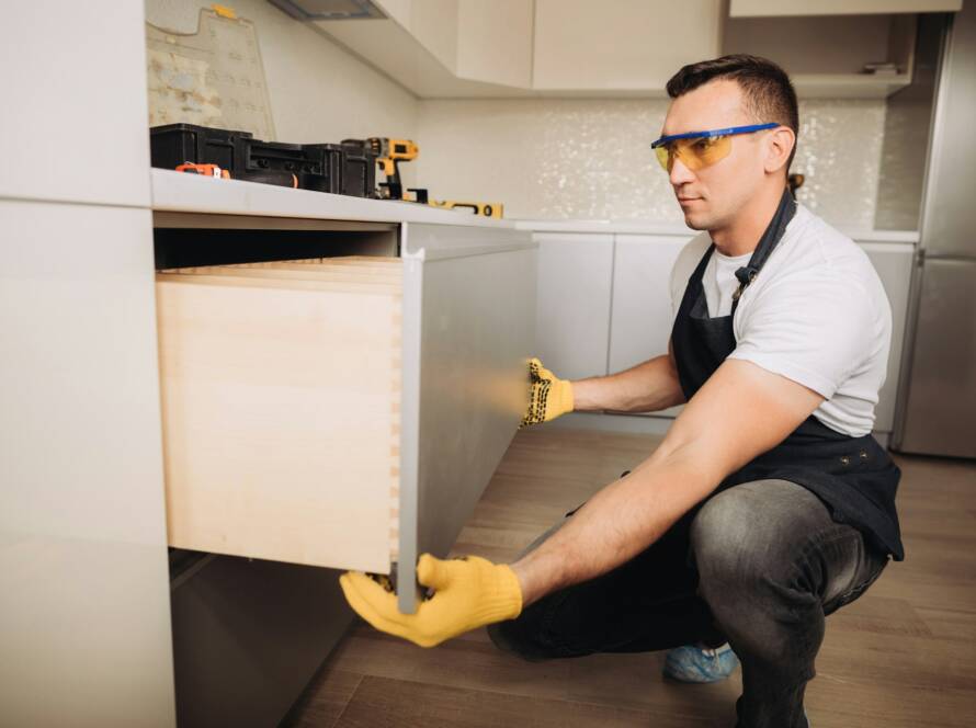 Maintenance man installing kitchen furniture