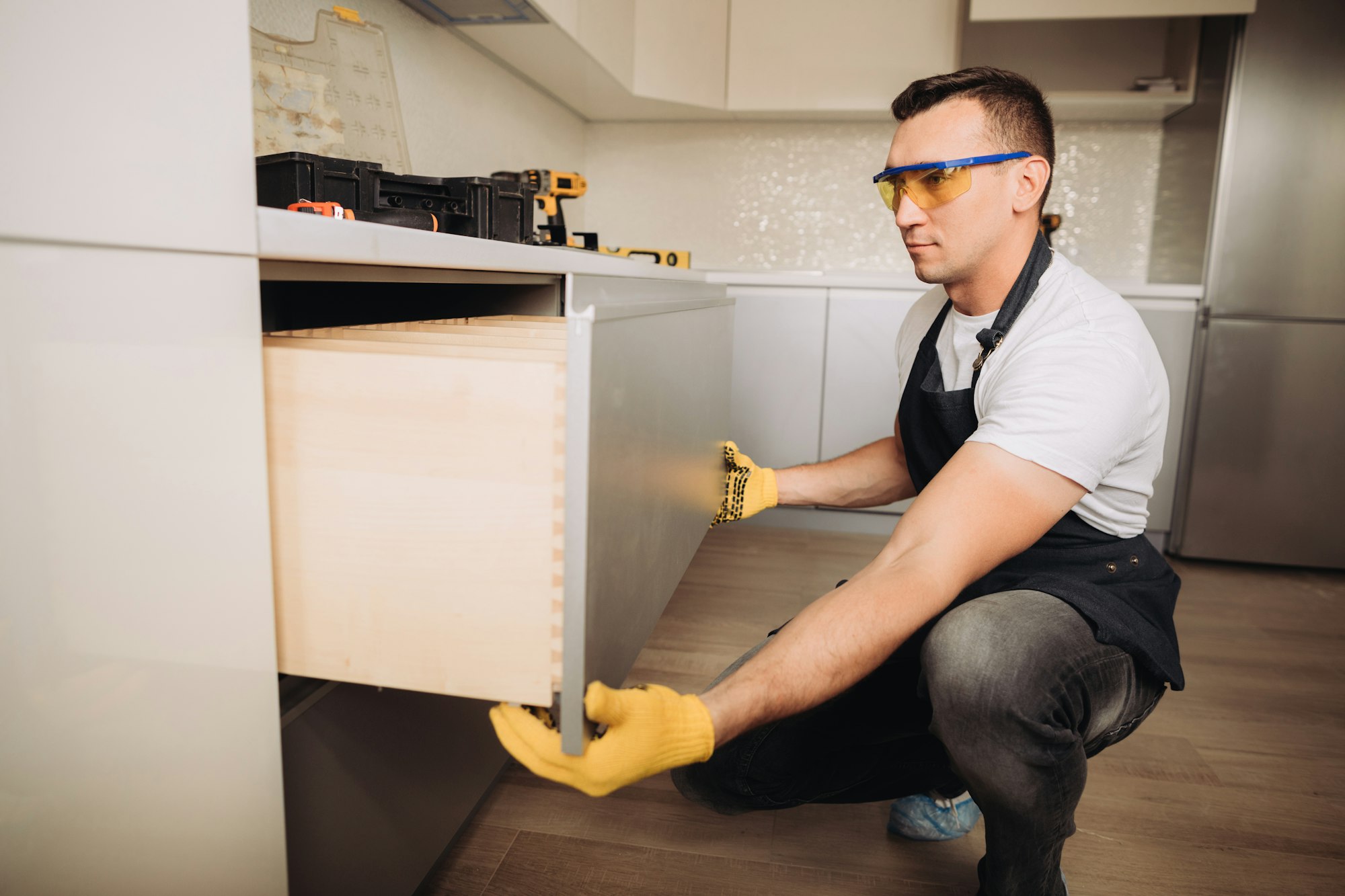 Maintenance man installing kitchen furniture